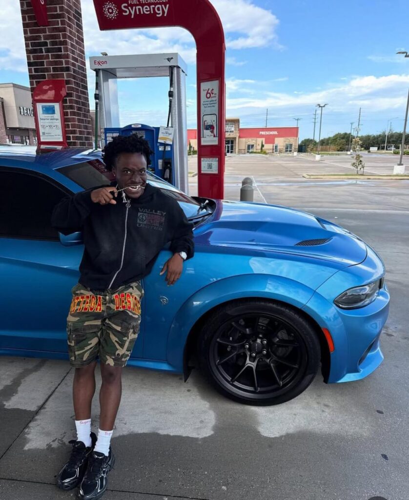 A picture of suburbbaby posing in from of his blue hellcat Daytona 
