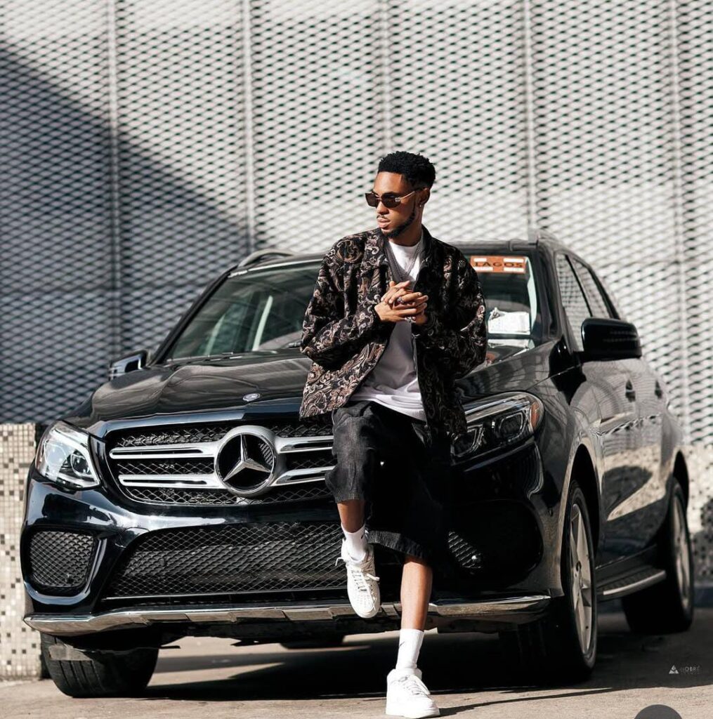 a picture of crispdal posing in front of his black mercedez benz gle